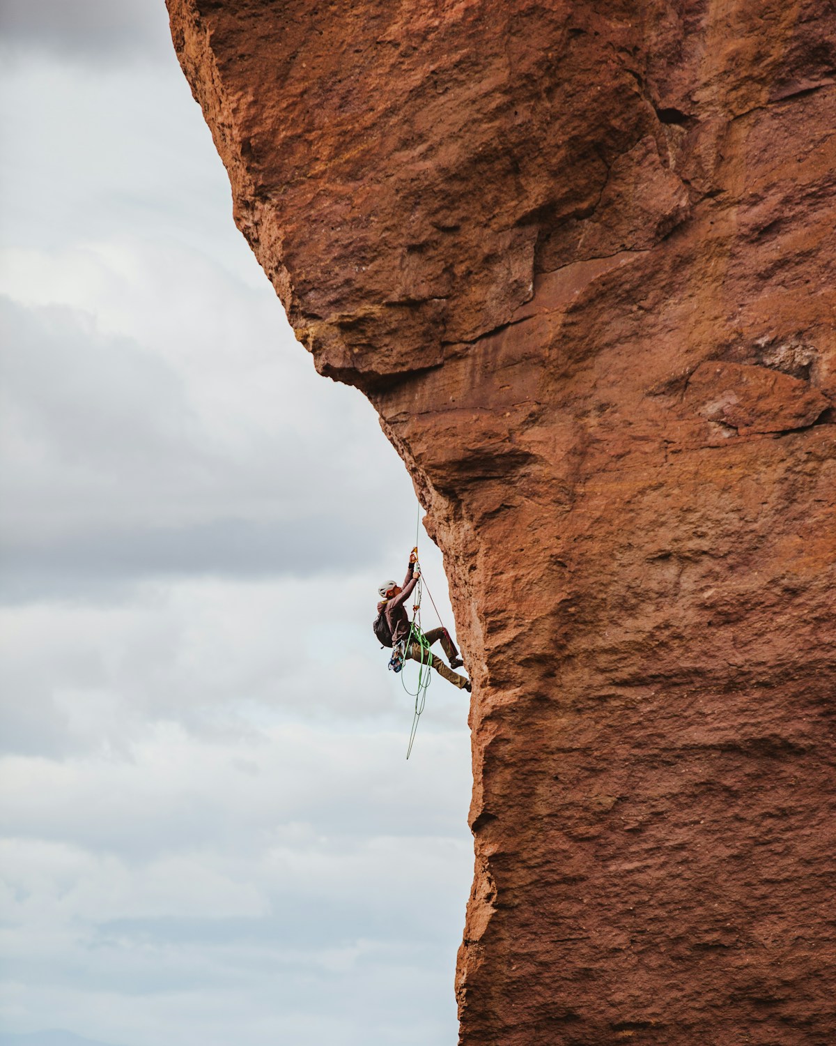 A climber scaling a rocky cliff face outdoors