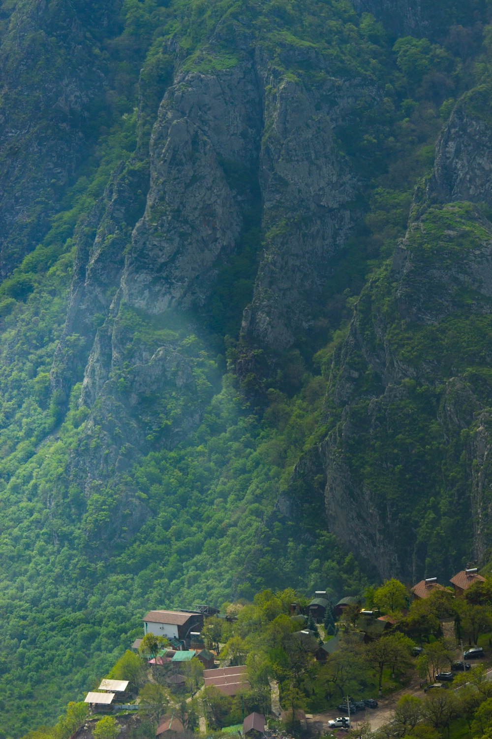 Houses at the foot of dramatic rocky canyon cliffs in the Syunik region, southern Armenia — near Old Khndzoresk cave village