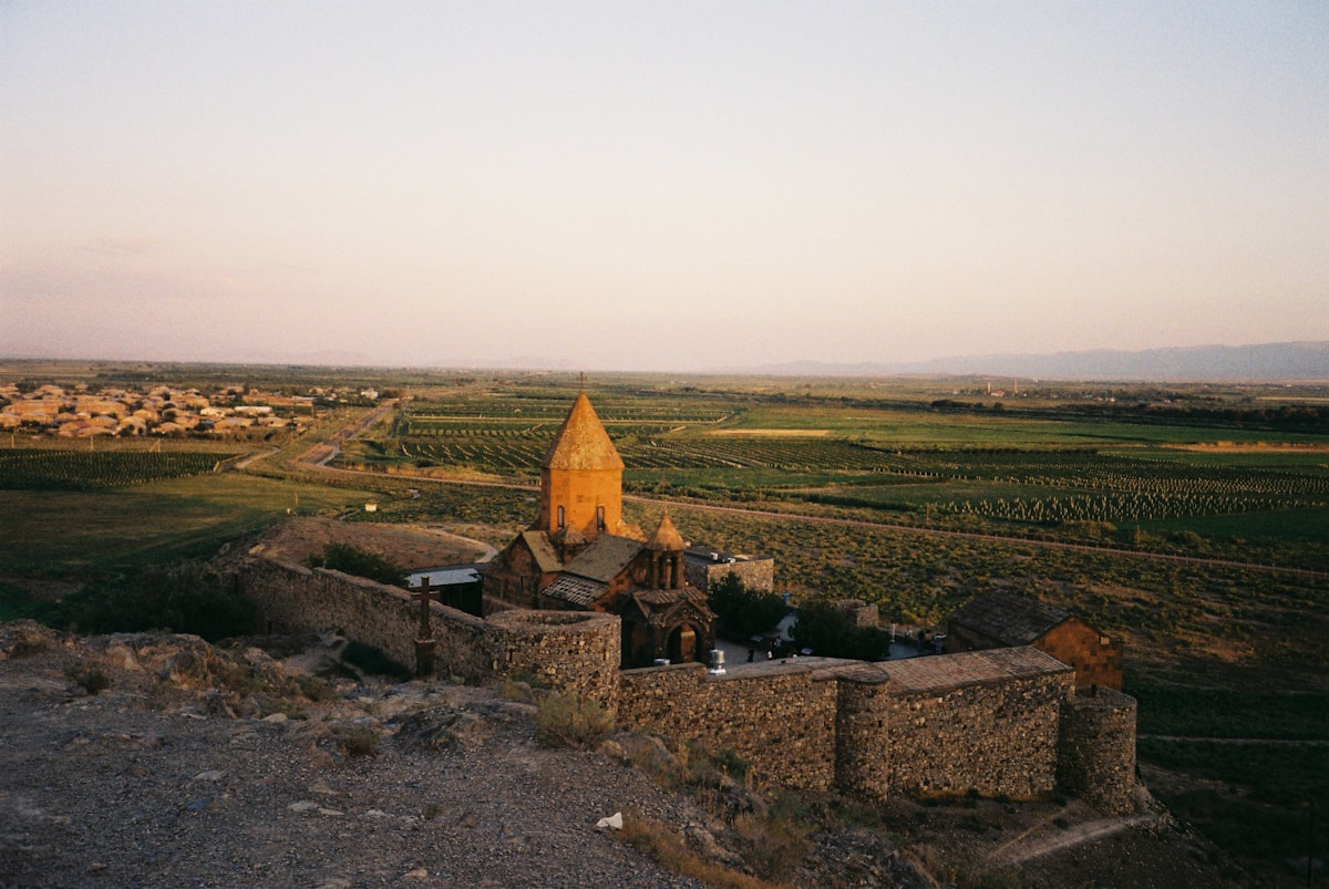 Khor Virap monastery complex at sunset on the Ararat plain, viewed from the hill above, Armenia