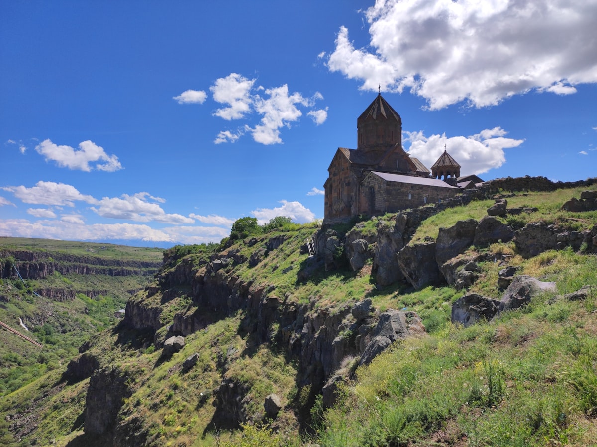 Saghmosavank monastery perched on the rocky edge of a basalt gorge in Armenia under a blue sky