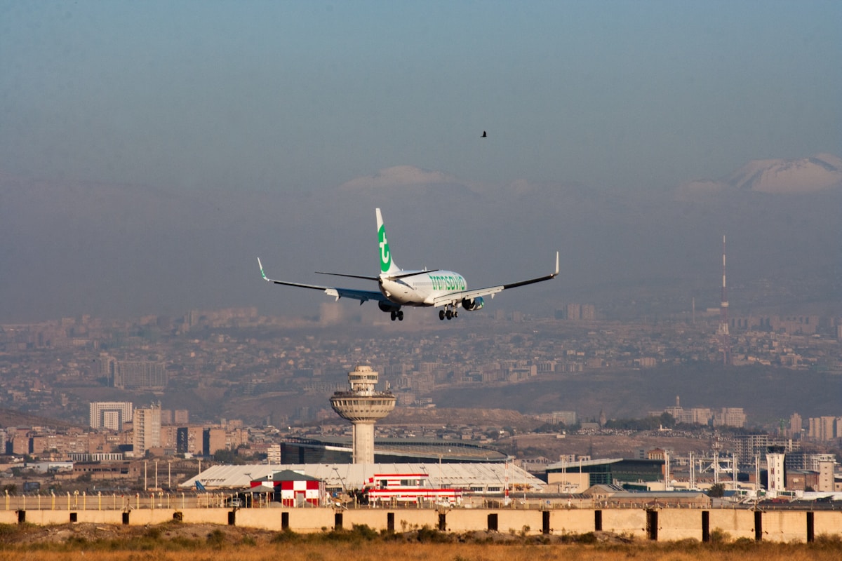Airplane on final approach over Zvartnots International Airport with Yerevan city and mountains in the background, Armenia