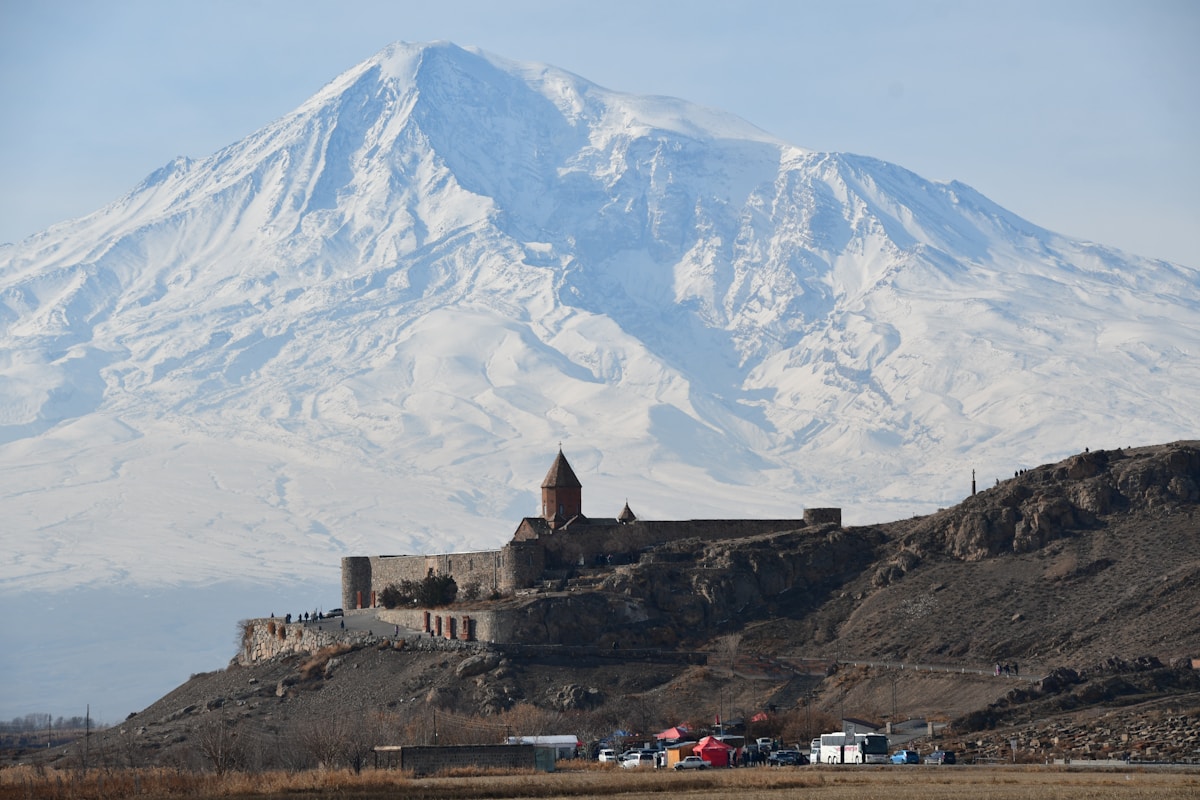 Khor Virap monastery on a low hill with the vast snow-capped summit of Mount Ararat rising behind it, Ararat Province, Armenia