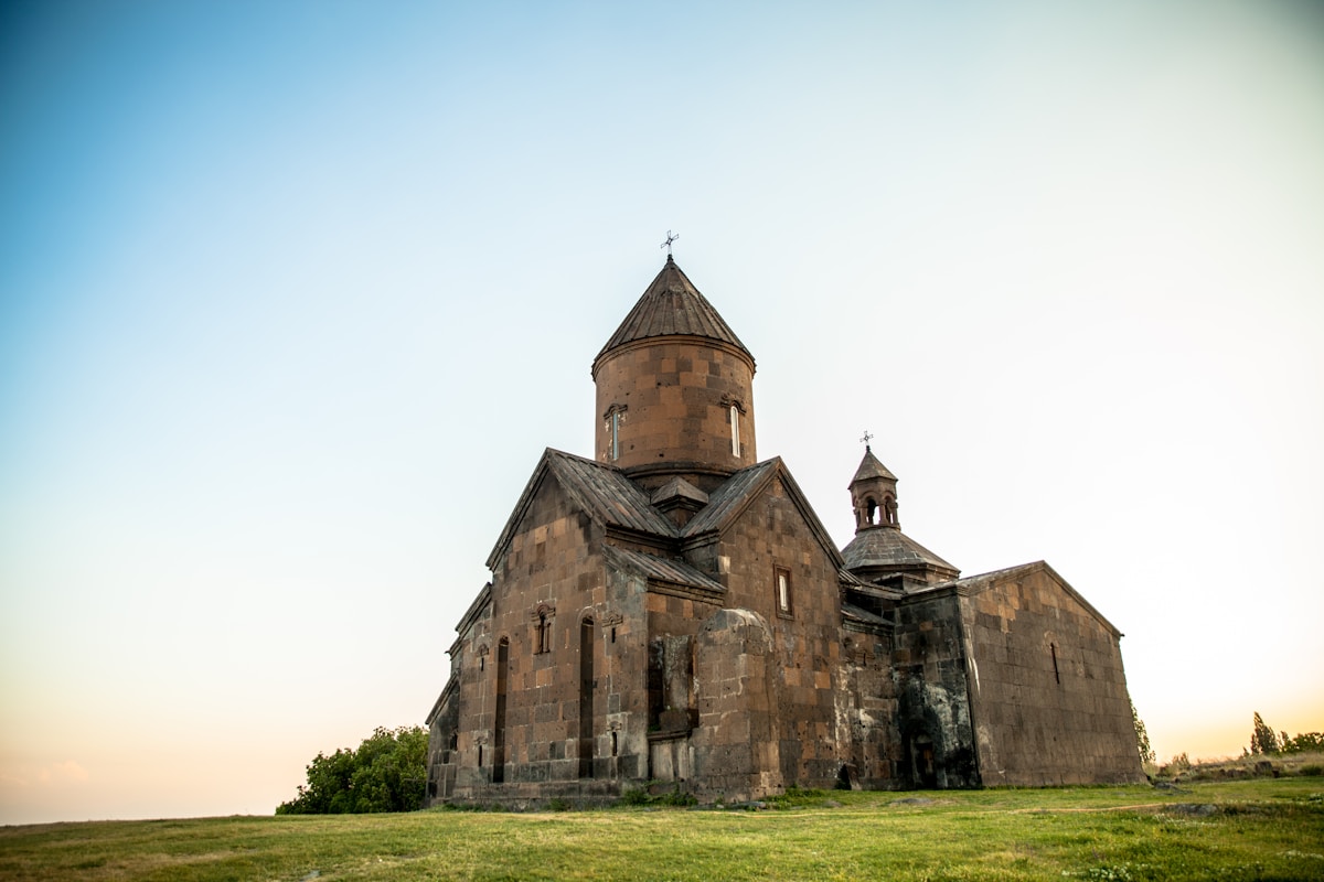 Saghmosavank monastery on green field at sunset — visiting Armenia in August