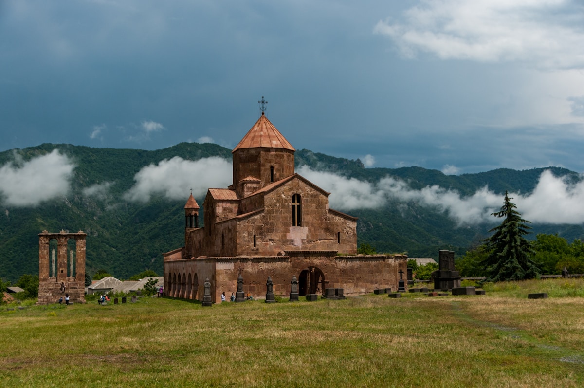 Odzun Church with green mountains and clouds — visiting Armenia in July