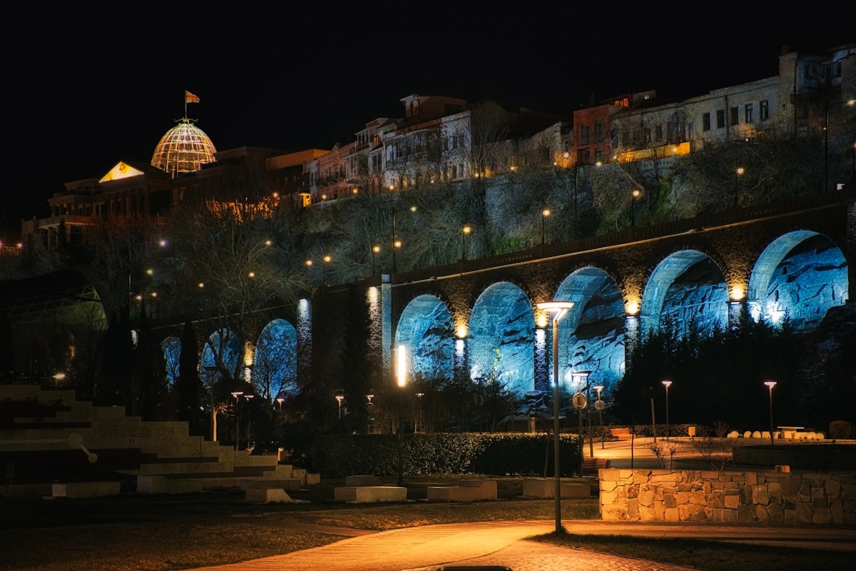 Rike Park and the illuminated arched bridge over the Mtkvari River at night, Tbilisi, Georgia