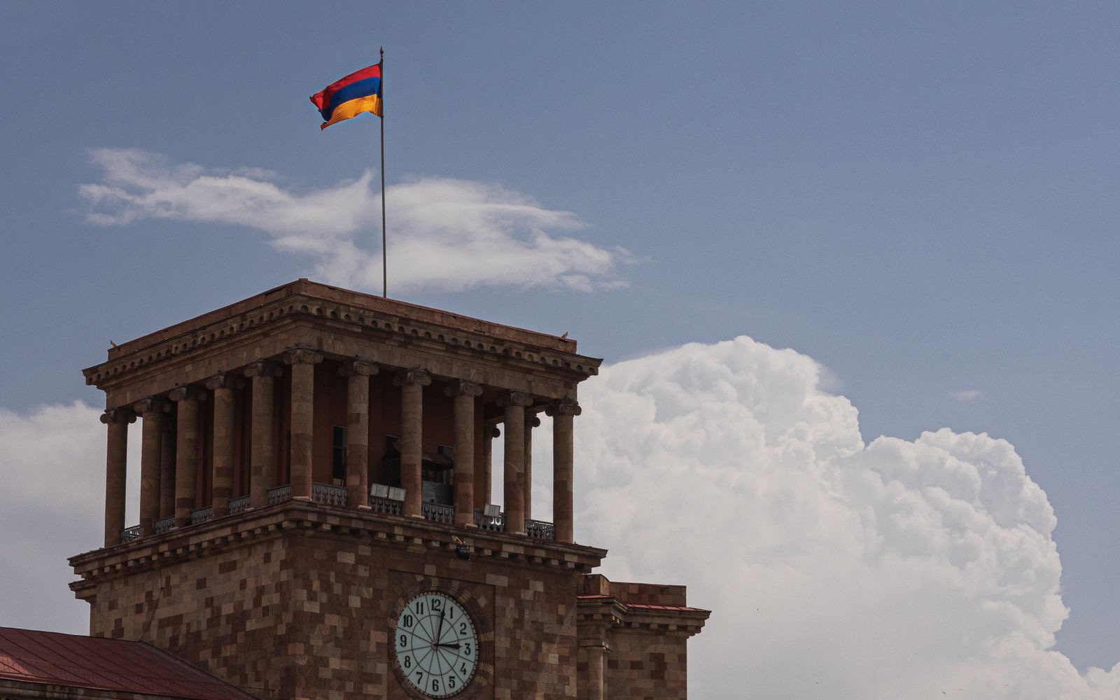 Armenian flag flying above the clock tower of a government building on Republic Square, Yerevan