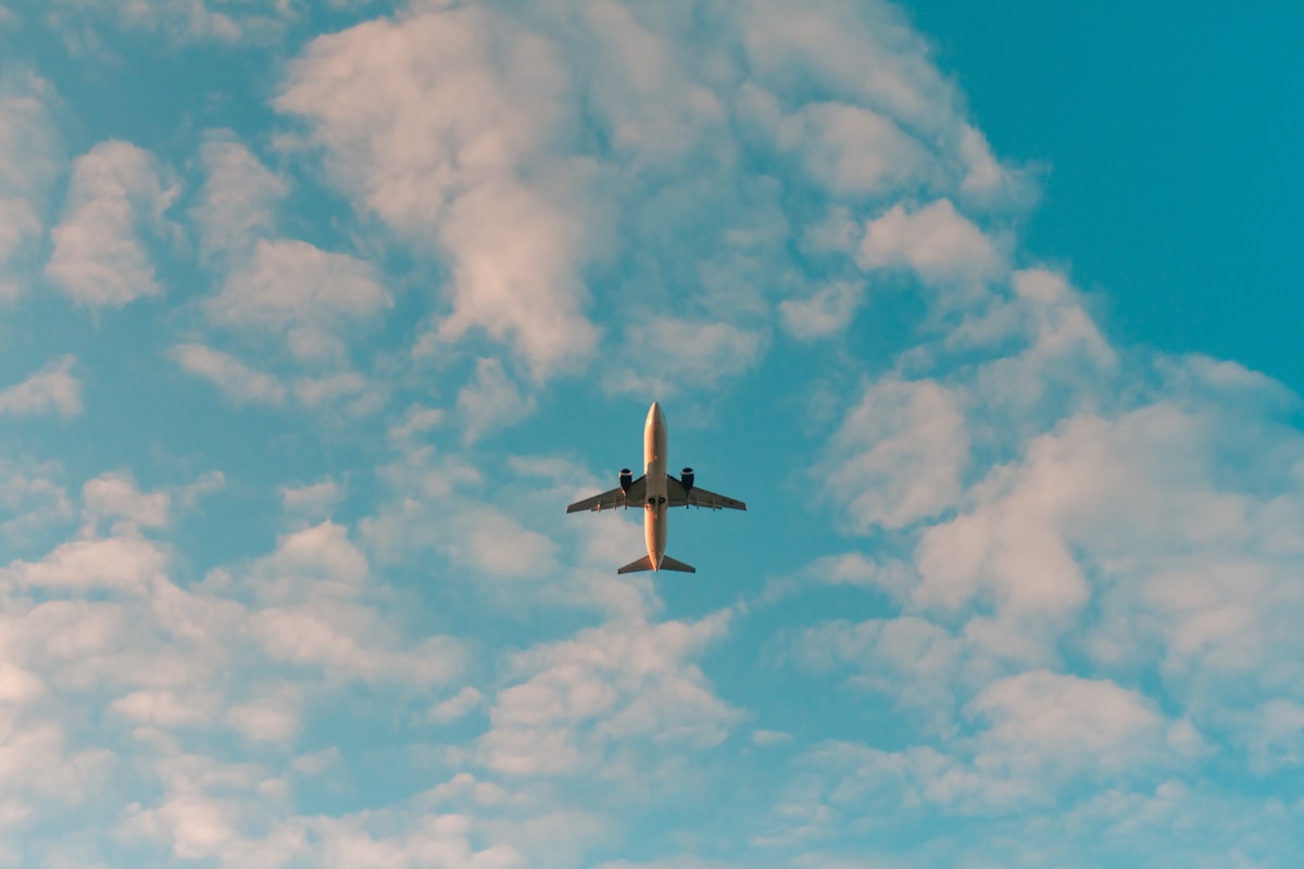 White commercial airplane in flight — flight delay compensation guide