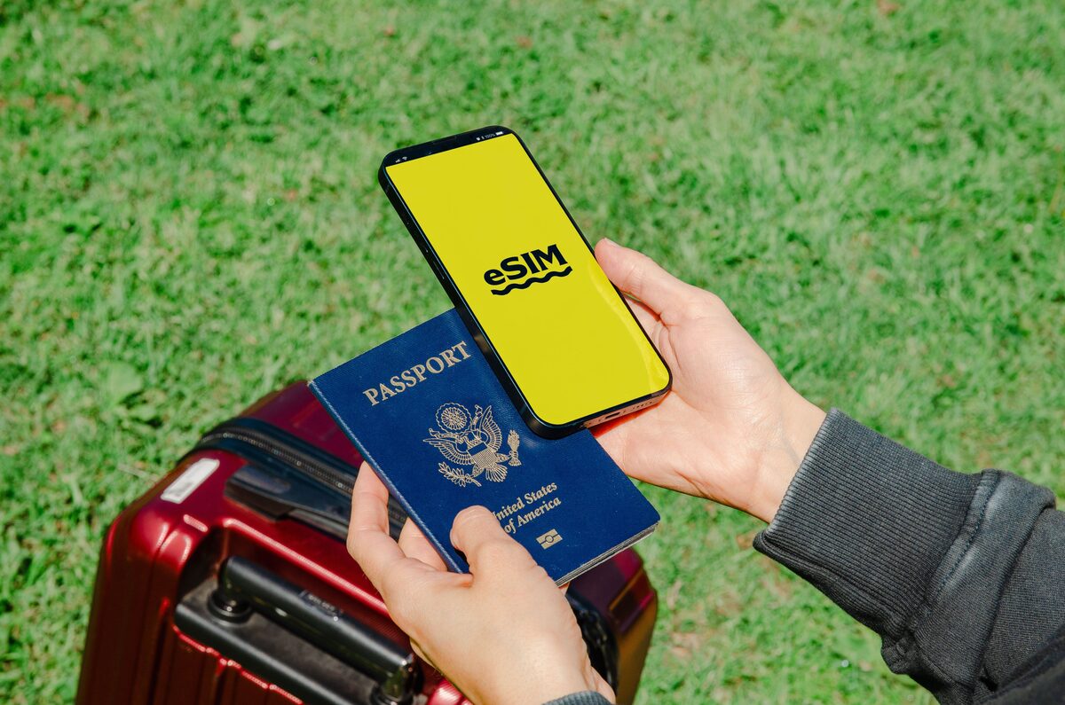 Smartphone with eSIM and passport near travel luggage - stay connected with an eSIM in Armenia